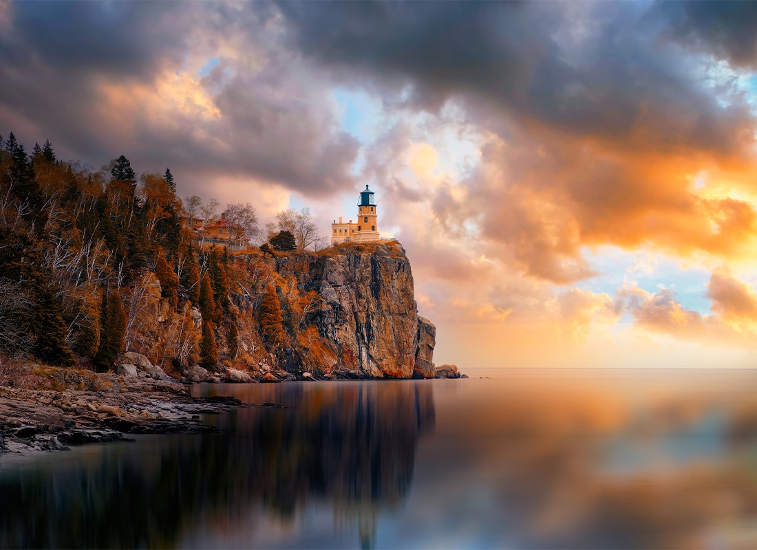 Contact - Beautiful Lighthouse Standing Tall on a Cliff as the Clouds Take Over the Sky